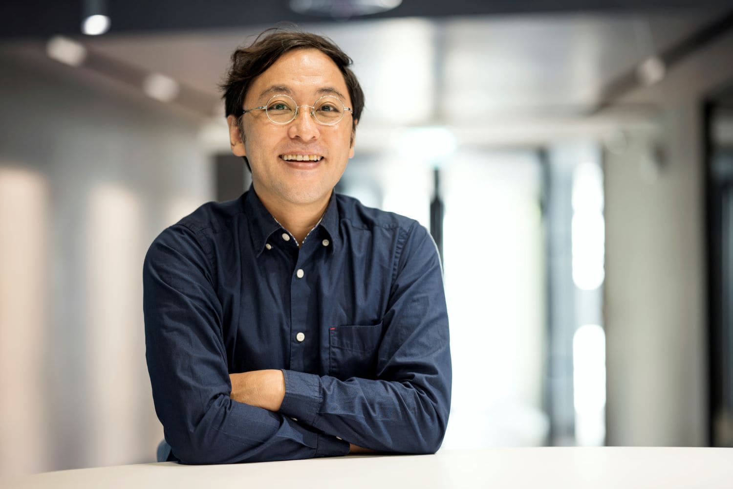 man smiling in office, arms crossed