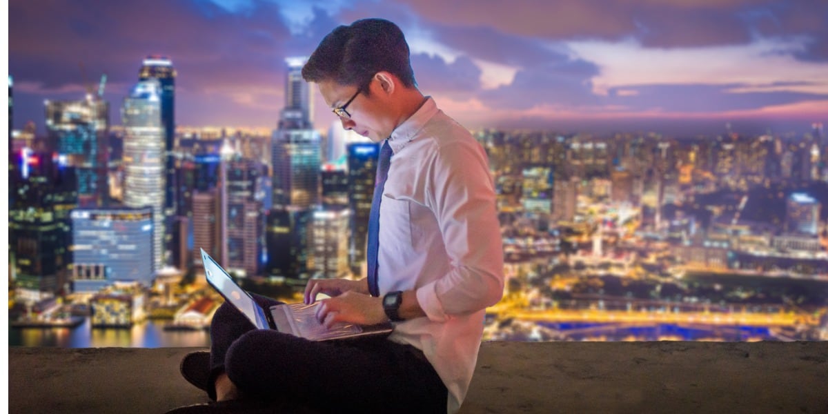 man on laptop in front of skyline view