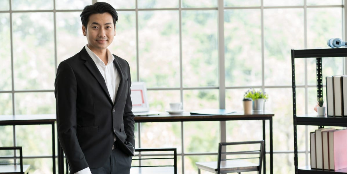 asian businessman in an office, smiling