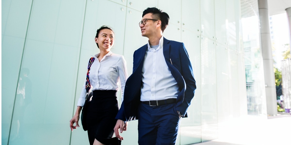 two coworkers walking outside of the business building