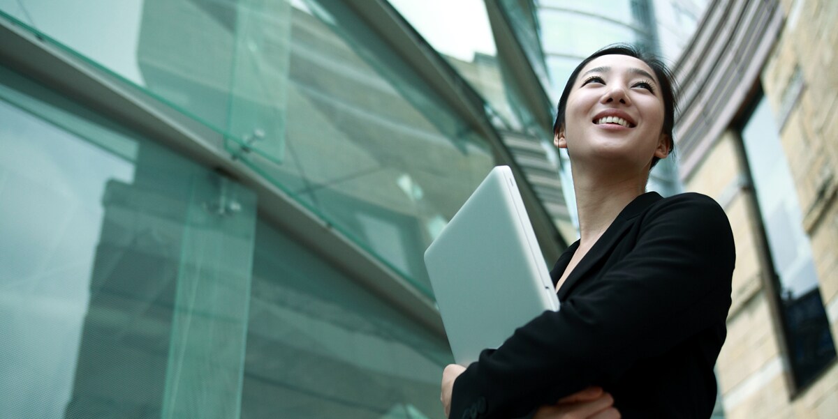 woman holding a laptop and smiling