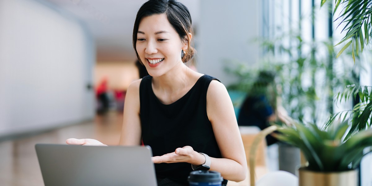 woman in office attending virtual meeting with laptop