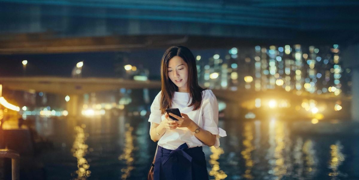 woman looking at phone, outdoors at night